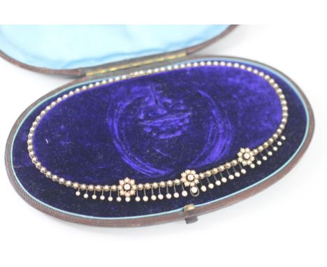 A cased 19th century seed pearl fringe necklace, the necklace designed as three seed pearl set flowerheads with central old c