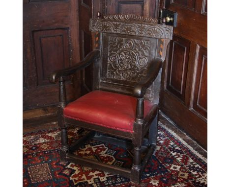 A 17th century oak Wainscot chair, the gadrooned top rail flanked by acorn finials above the back panel carved with a foliate