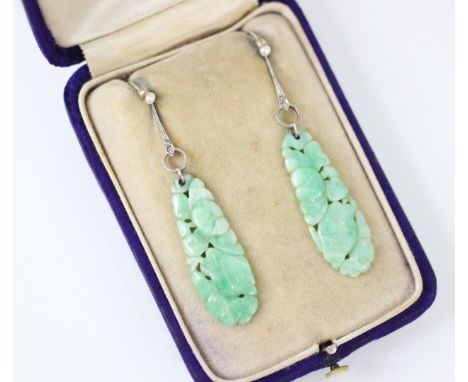 A pair of Art Deco jade, diamond and seed pearl drop earrings, the tapering oval panel of jade carved with fruit and flower d
