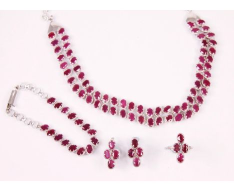 A suite of ruby set jewellery, comprising an oval cut ruby necklace with matched bracelet, a pair of earrings with matched de