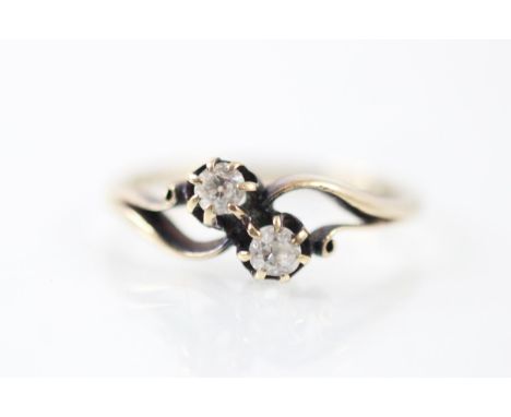 A 20th century diamond 'toi et moi' ring, the two old cut diamonds set within an openwork yellow metal mount, with plain poli