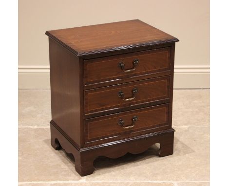 A small reproduction mahogany chest of drawers, late 20th century, with a crossbanded top over three drawers applied with swi
