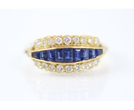 A 18ct yellow gold untested sapphire and diamond ring, the central nine graduated calibre cut sapphires within a border of tw