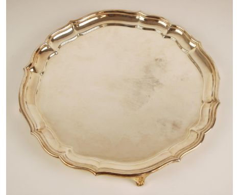 A silver salver, Elkington &amp; Co, Birmingham 1948, of circular form within ogee cast rim upon four bracket feet, 26cm diam