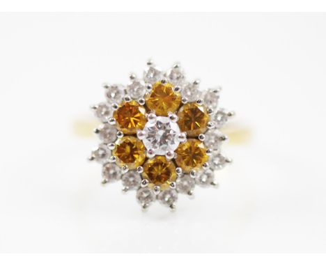 A late 20th century untested yellow and colourless diamond cluster ring, the ring designed as a flower head with the central 