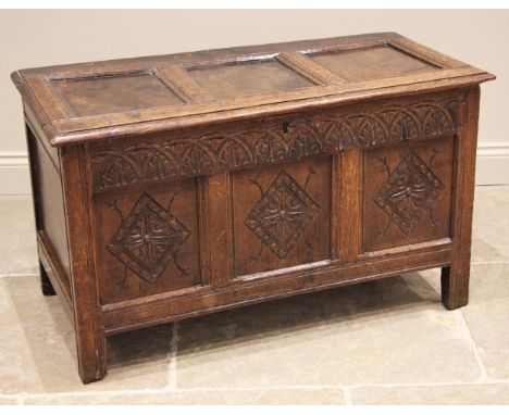 A carved oak coffer, late 17th/early 18th century, the three panel hinged top (detached), over a lunette carved frieze and th