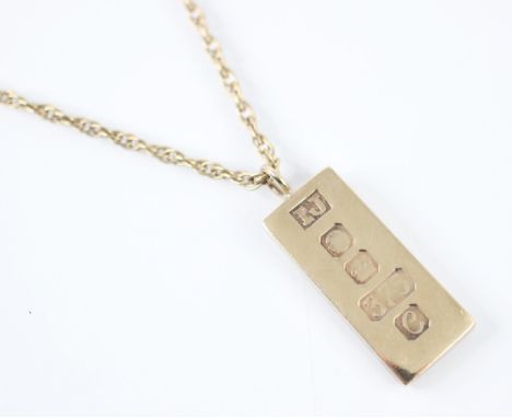 A 9ct yellow gold ingot pendant, stamped 'IJ' Sheffield 1977, upon a later associated yellow metal twist link chain, with bol