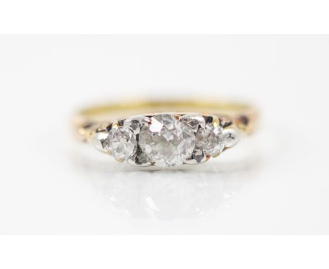 A Victorian three stone diamond ring, the central old cut diamond with old cut diamond to each side within a yellow metal car