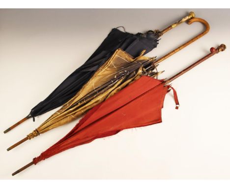 A silk parasol, 19th century, the scroll relief cast gilt brass handle set with with an enamel on porcelain three quarter len