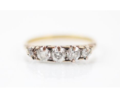 A late 19th diamond five stone ring, the five graduated old cut and mixed cut diamonds within a yellow metal carved mount, le