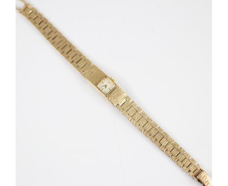 A 9ct yellow gold ladies wristwatch, the square cream coloured dial with baton markers, set to a textured rectangular case, c