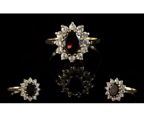 A Vintage 9ct Gold Attractive Garnet And CZ Set Cluster Ring.  Flower head design. The central Garnet surrounded by 12 CZ's. 