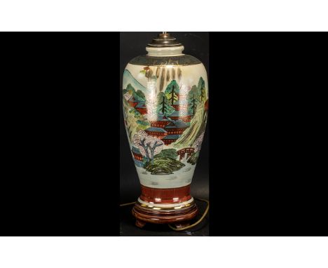 Oriental Style Table Lamp with porcelain base, depicting scenes of houses and rivers.  Raised on a wooden base.  Measures 21'