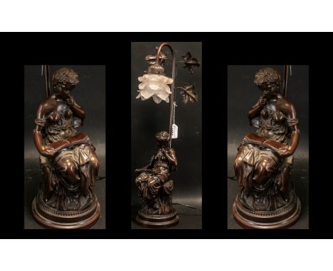 A Modern Decorative Bronzed Table Lamp depicting a classical maiden reading below branches. With a pink frosted shade. Height