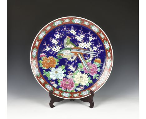 A large Japanese porcelain charger early 20th century, the central well decorated with two pheasants on a Prunus branch, with
