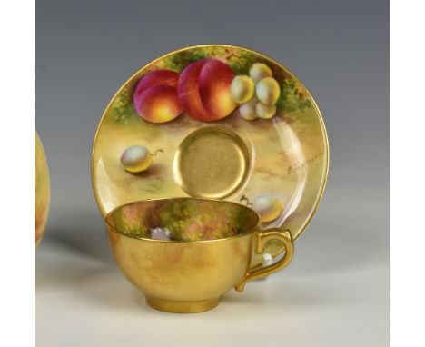 E Townsend for Royal Worcester miniature cabinet cup and saucer, decorated with berries fruit, the cup having gilt exterior, 