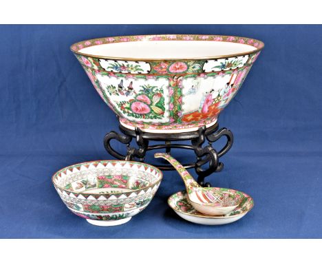 A modern Chinese punch bowl on hardwood stand floral decorated, the shaped reserves with figures in interior setting or birds