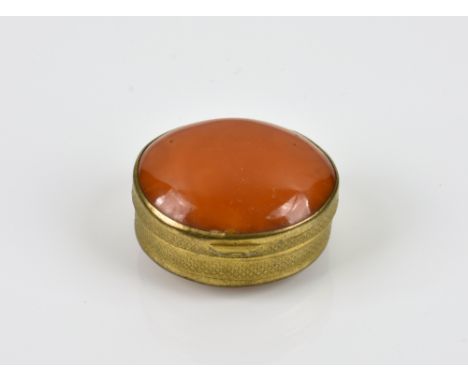 A gilt metal and amber butterscotch trinket box of oval form, having convex amber butterscotch cover and base, the sides havi