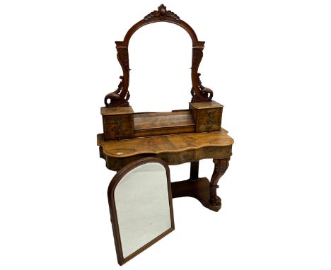 19th century figured walnut dressing table, the raised bevelled mirror back in carved foliage frame with scrolled terminals, 