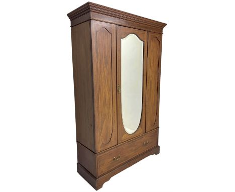 Edwardian figured mahogany and satinwood banded wardrobe, enclosed by shield shaped bevelled mirror door, flanked by panelled