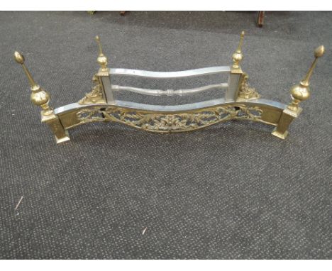 An ornate brass and chrome fire grate front