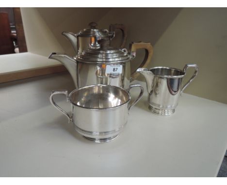 A silver plated four piece tea set of plain form having fruit wood handles, Walker & Hall