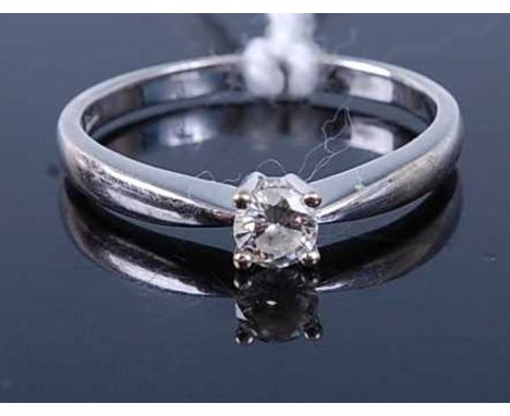 A white metal diamond solitaire ring, the four claw set brilliant weighing approx 0.2 carats, stamped 750, 1.8g, size K