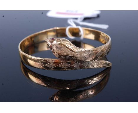 A modern silver gilt snake bangle, with hinge action and red paste set eyes, 25.3g, dia.62mm