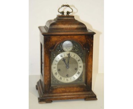 A 20th century walnut cased bracket clock, the silvered dial showing Roman numerals with pierced mask spandrels, the 8-day mo