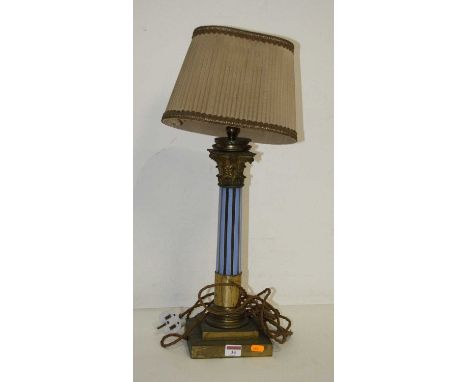 An early 20th century brass and coloured glass table lamp in the form of a Corinthian column mounted upon a stepped square pl