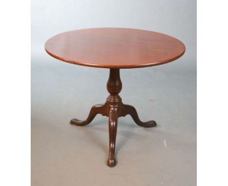 A George III mahogany tea table,with tilting circular top on birdcage stem and tripod base,Diam.121cm H.70cm 