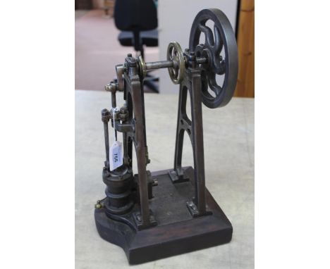 A cast iron and steel steam engine standing on mahogany base