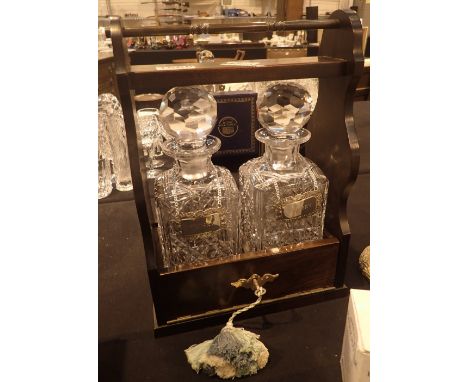 Mahogany tantalus with two matching heavy cut glass decanters with star cut bases, each with a silver plate decanter label, S