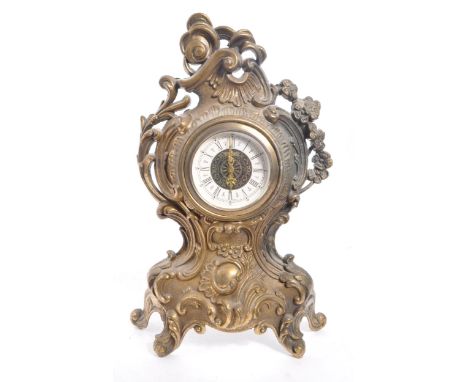 A 20th Century ornate Art Nouveau style West Germany face moulded gilt metal mantel clock having flourishes and foliate decor