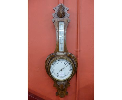 An early 20th Century carved oak aneroid barometer