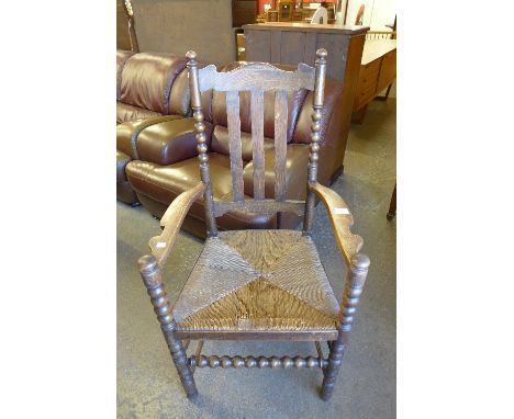 An oak bobbin turned rush seated armchair