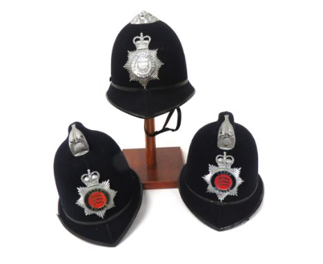 Three Various Police Helmetsconsisting 2 x examples with top comb.  Plated front mount.  Plated and enamel , QC Essex Police 