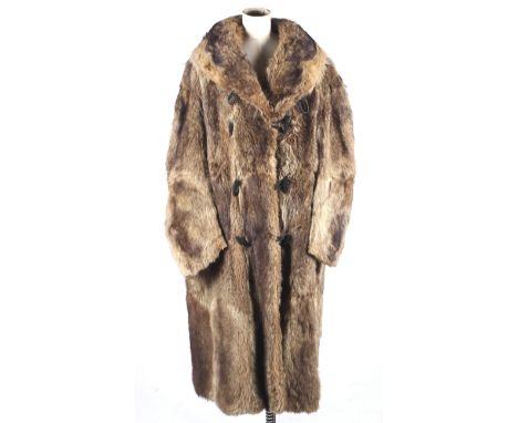 A vintage full length fur trench coat, possibly raccoon. With a wide collar and toggle fastenings, lined in quilted fabric wi