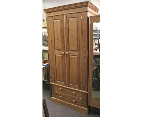 A 20th century double door pine wardrobe. With hanging rail and two lower drawers. H192cm x W88cm x D61cm