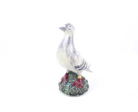 An indistinctly signed Portuguese ceramic figurine of a racing pigeon. Modelled with a ring on its leg, H25cm.