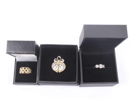 Three boxed items of yellow metal jewellery. Including a three stone ring, brooch (two heart) and Celtic band