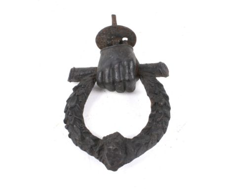 A 19th century cast iron door knocker. In the form of a hand holding a laurel wreath with a lions head mask. H18cm