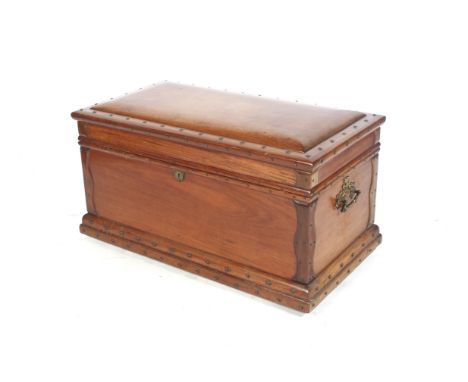 A 19th century teak travelling trunk. WIth domed lid, gilt metal fittings and rivet details, a lowering shelf fitted inside t