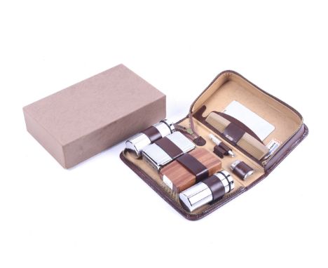 A vintage gentleman's vanity set. The brown cowhide case zipping open to reveal a fitted interior containing a mirror, comb, 