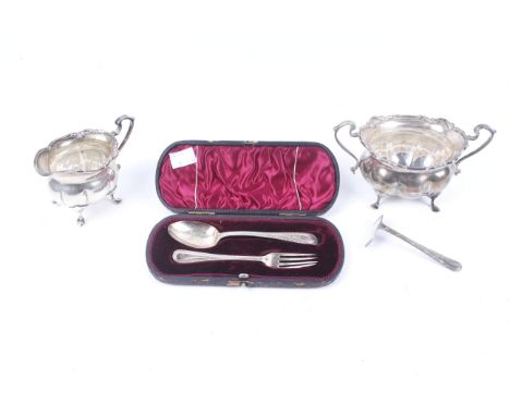 A small collection of silver including a lobed-oval milk jug and sugar bowl. With floral scroll borders, double-scroll handle