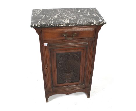 An Edwardian mahogany marble top cupboard. Having a single carved panel door with a drawer above and reeded and moulding deco