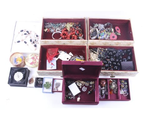 A collection of assorted gem set and other earrings and costume jewellery. In a red silk covered jewellery box and a beige je