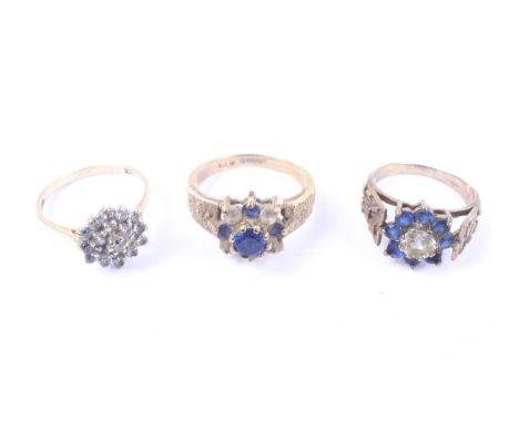 Three vintage 9ct gold, blue and colourless stone cluster rings. Comprising; a cubic zirconia hexagonal cluster, size M; a ce