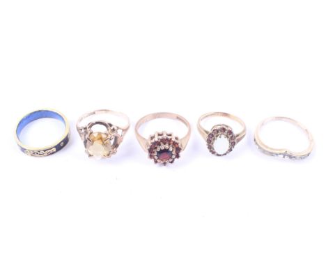 A group of four gold and gem set rings and an enamelled band ring. The rings include a 9ct gold, white opal and garnet oval c