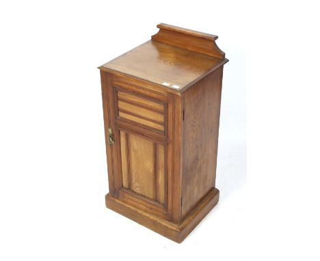 A 20th century oak pot cupboard. With a cornice to the the back, a single panelled door opening to reveal a single shelf, on 